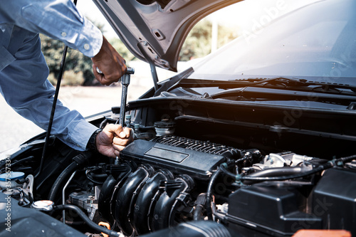 Auto mechanic hands using wrench to repair a car engine. concepts of car care fix repair service and insurance.