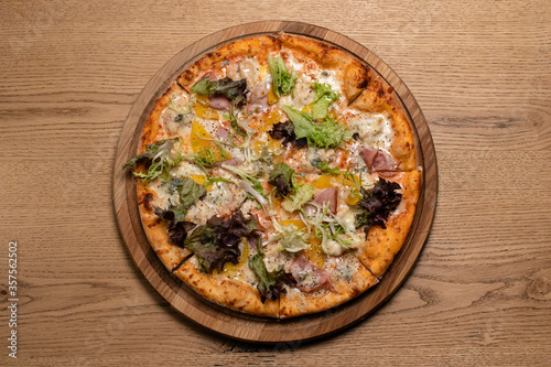 Delicious juicy large pizza on a wooden table. Pizza with chicken