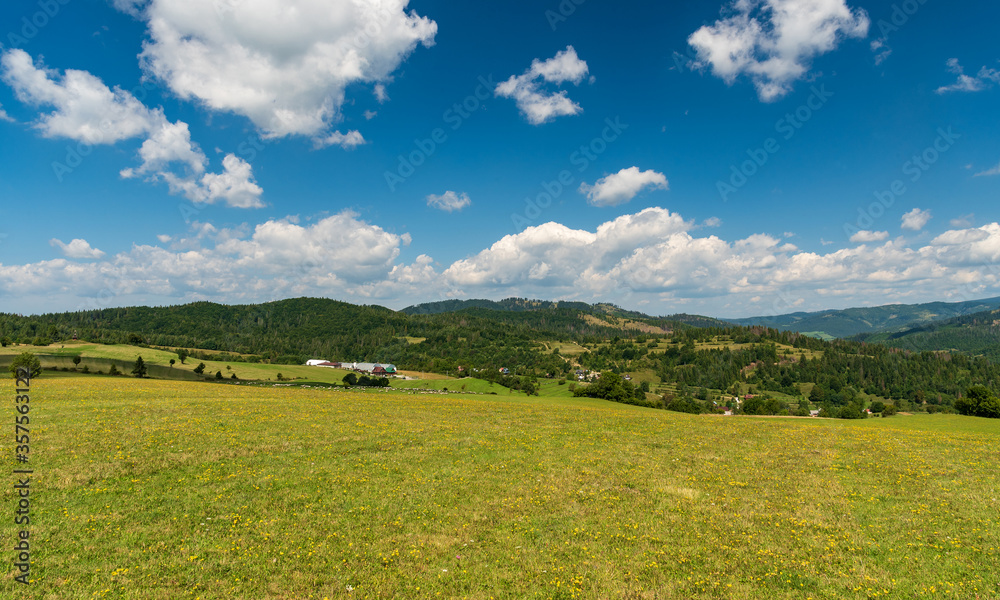 Beuatiful surrounding of Lutise village in Slovakia with meadows, houses and farm of uuper part of Lutise village, sheep, chapel on Zlien hill and hills