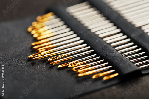 A set of sewing needles on a black background.