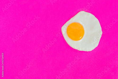 One fried egg on pink background, pop art, isolated from the right side
