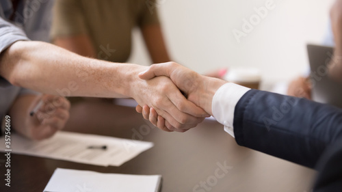 Close up business partners handshaking after successful negotiations wide horizontal image, making agreement, greeting, employees shaking hands at briefing, congratulating with promotion