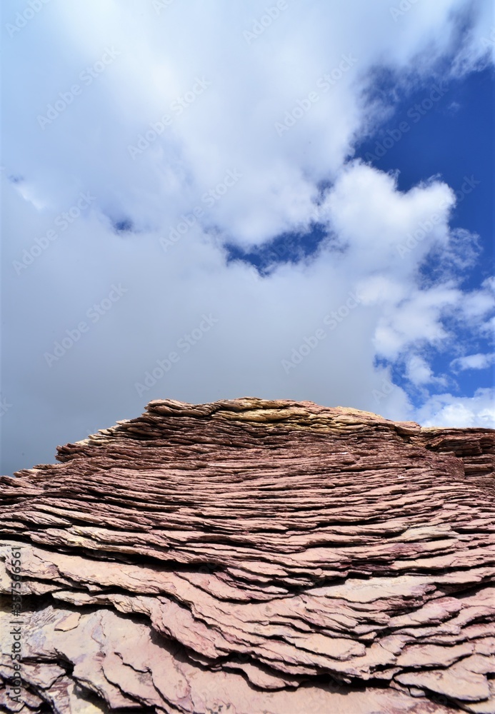 red slate against a blue sky with white clouds behind