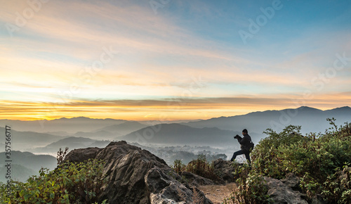 A Photographer in action during sunrise in the mountains