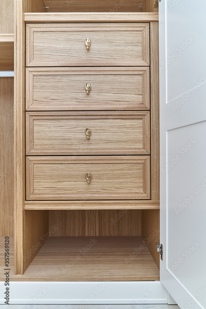 White wardrobe with wooden drawers and shelves. Wooden filling of wardrobe