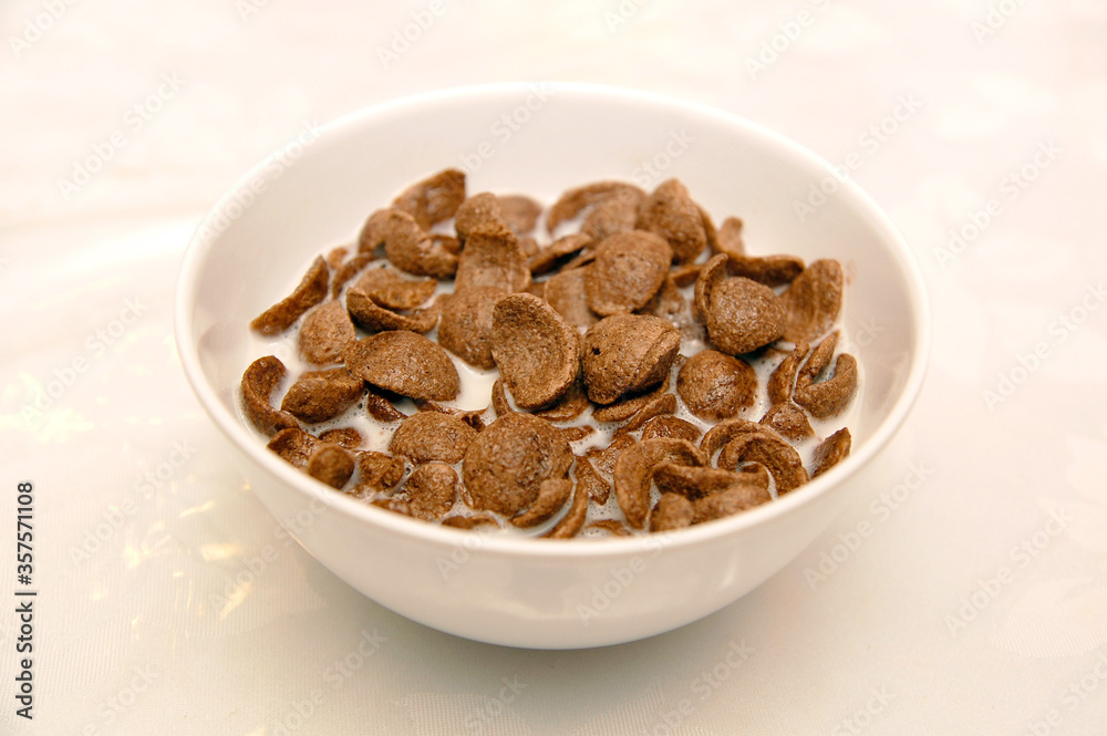 Chocolate cereals in bowl of milk as breakfast meal Chocolate cereals in bowl of milk as breakfast meal
