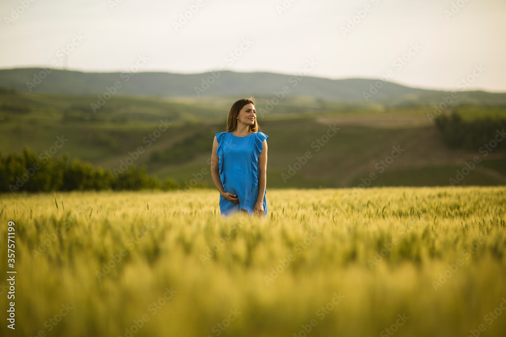 Young pregnant woman in the field