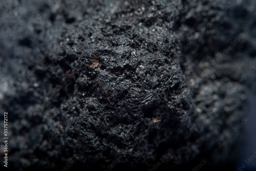 Blurred black background in soft focus with hard coal at high magnification