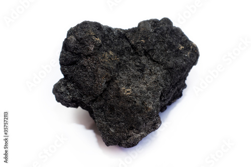 A piece of black coal from the mine on a light background.