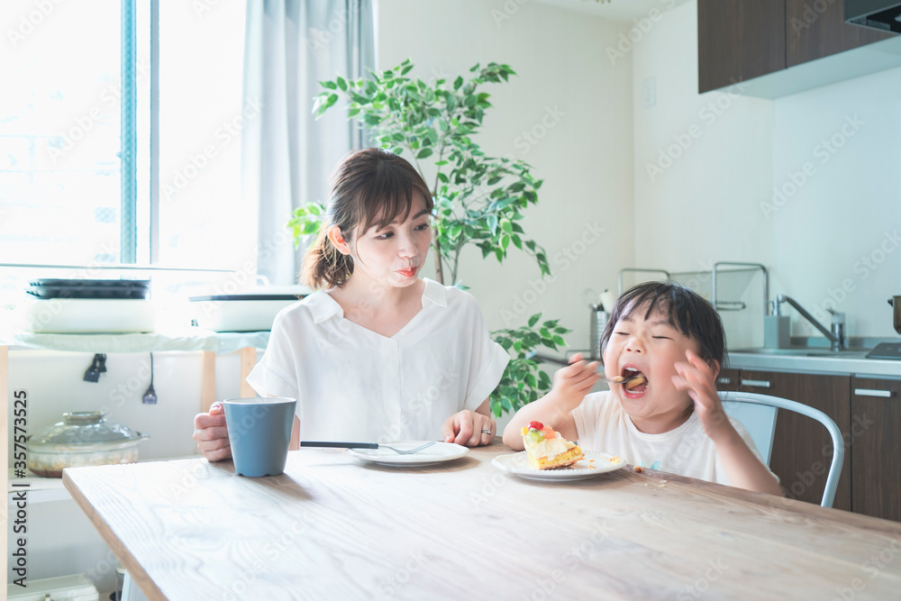 部屋のテーブルでケーキを食べる親子 部屋のテーブルでケーキを食べる親子