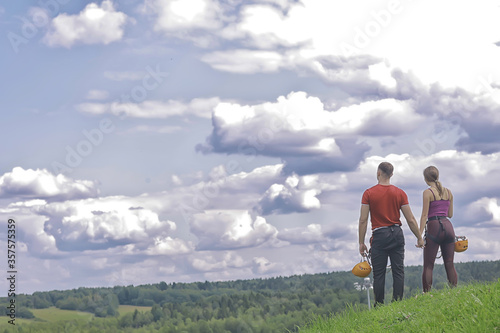 love couple in helmets outdoor activities nature  rope climbing park  against the sky