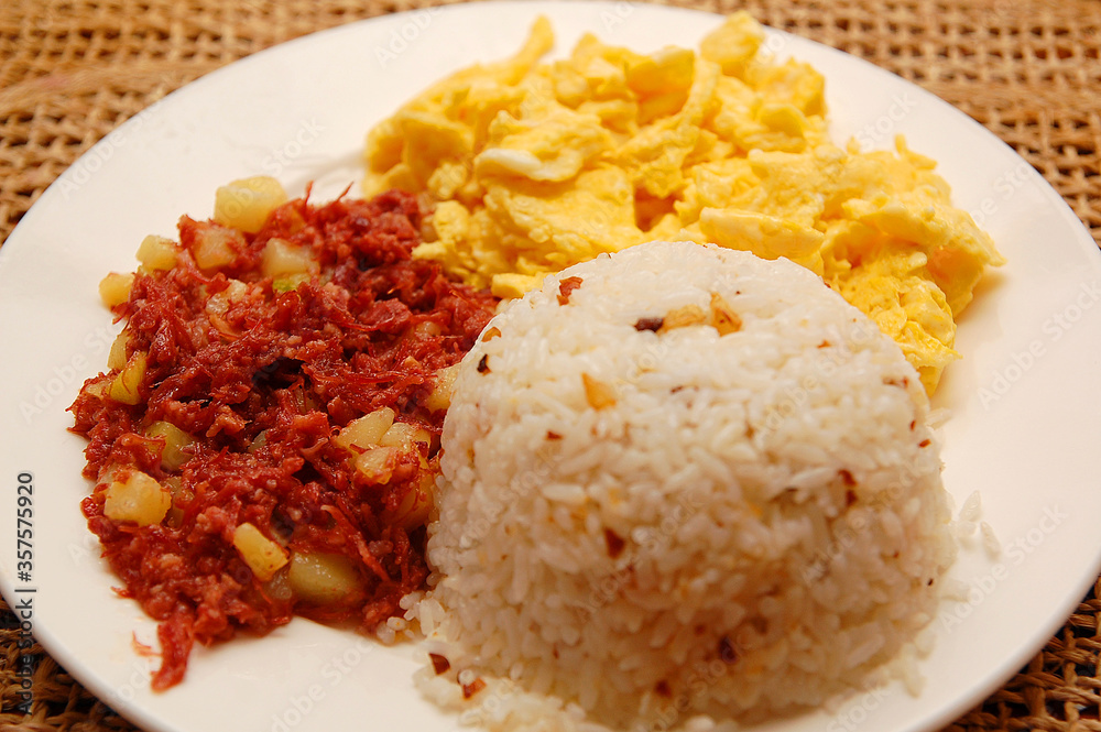 Breakfast meal consists of garlic rice, scrambled egg and corned beef on plate serve in hotel resort Breakfast meal consists of garlic rice, scrambled egg and corned beef on plate serve in hotel resort