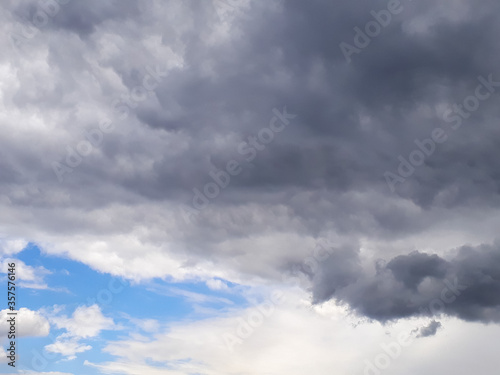 Heavy gray rain clouds in the blue sky. Atmosphere, air, cloudy, soon rain.