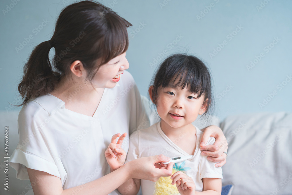 母親に体温を計測してもらう女の子 母親に体温を計測してもらう女の子