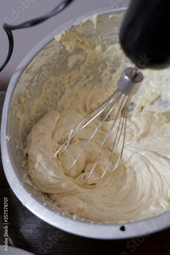 Beating cream. Making butter cream filling. Making torte cupcakes with buttercream filling. Motion view.