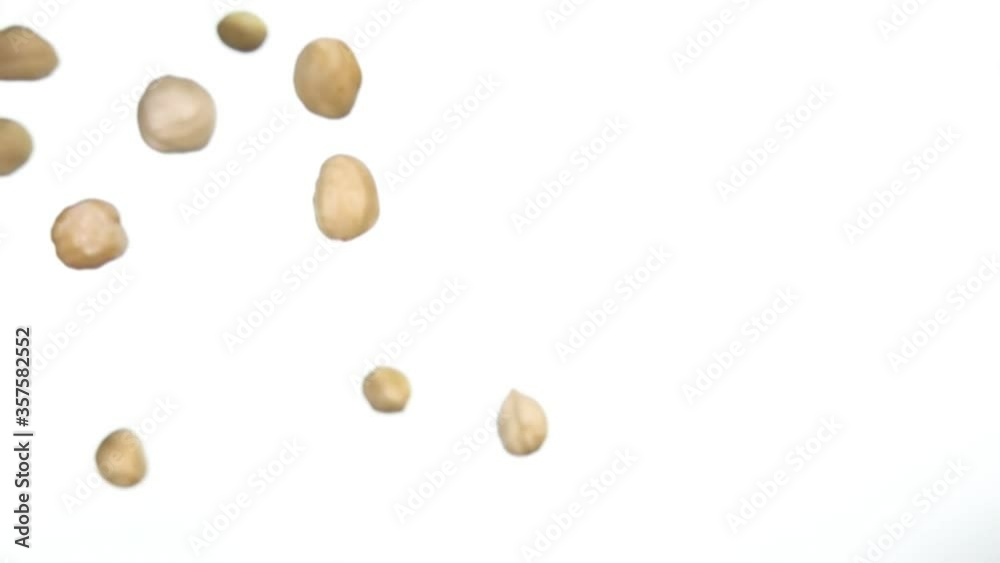 Hazelnuts are falling down and rotating on white background in slow motion Hazelnuts are falling down and rotating on white background in slow motion