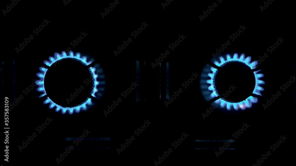 Hand with lighter slowly ignites the left side of the stove next to the right side, then goes out. Seen up close, from above Hand with lighter slowly ignites the left side of the stove next to the right side, then goes out. Seen up close, from above