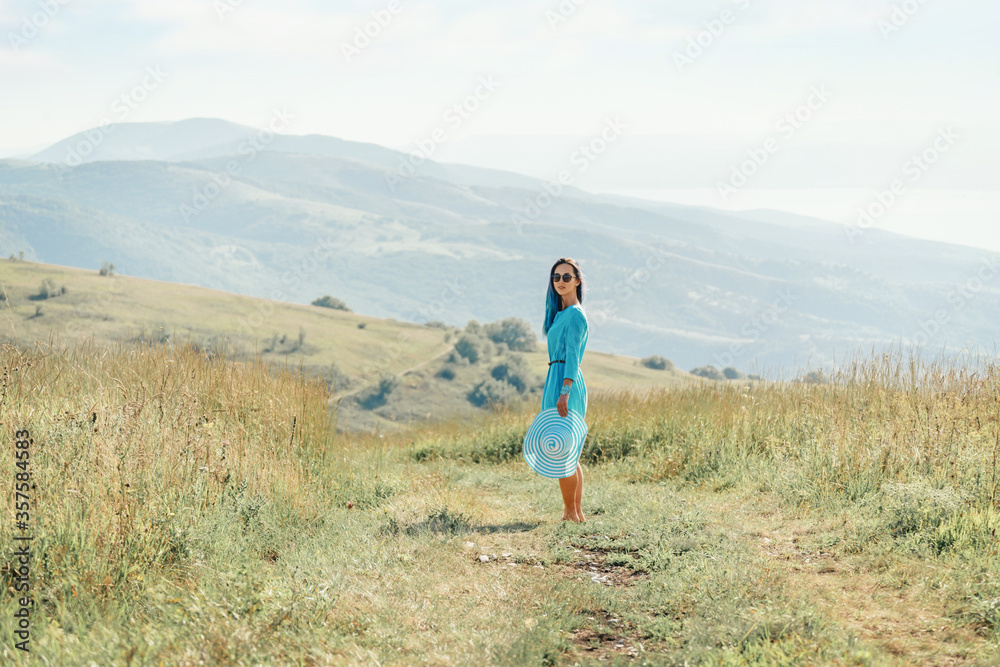 Beautiful young woman walking on rural path in summer.