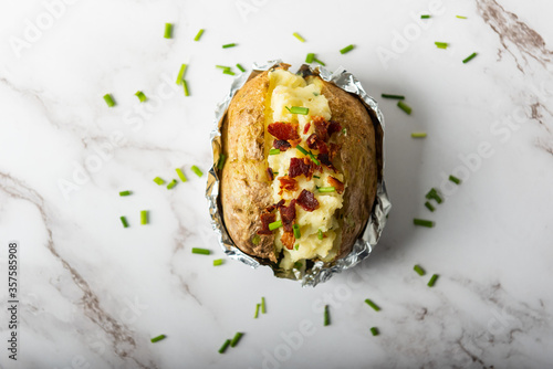 Home cooking jacket potato, filled with sour cream, bacons and chives photo