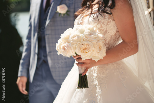 Luxury white wedding bouquet in the hands of the bride
