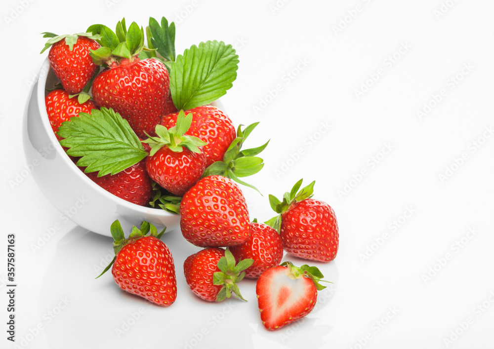 Fresh raw organic strawberries in white ceramic bowl plate on white background with berries next to it. Fresh raw organic strawberries in white ceramic bowl plate on white background with berries next to it.