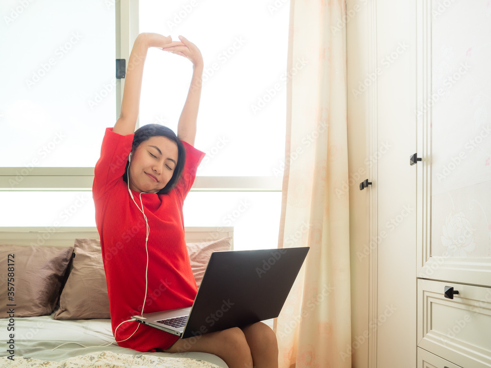 Asian woman Finished working in the bedroom by the laptop Asian woman Finished working in the bedroom by the laptop