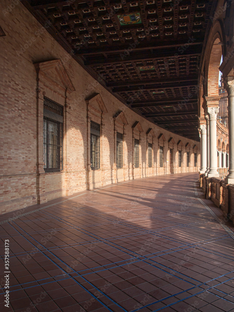 Gallery with columns and wooden coffered ceiling of the building of the Plaza de España in Seville
