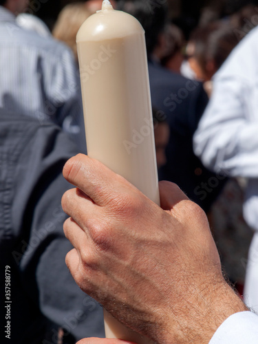 Hand of a Nazarene holding a candle in an Holy Week procession in Seville, Spain