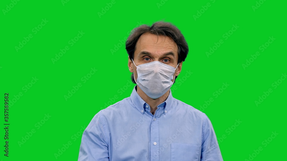 Portrait of adult man in protective mask looking at camera on green screen background, Covid-19 Pandemic, Chroma key Portrait of adult man in protective mask looking at camera on green screen background, Covid-19 Pandemic, Chroma key