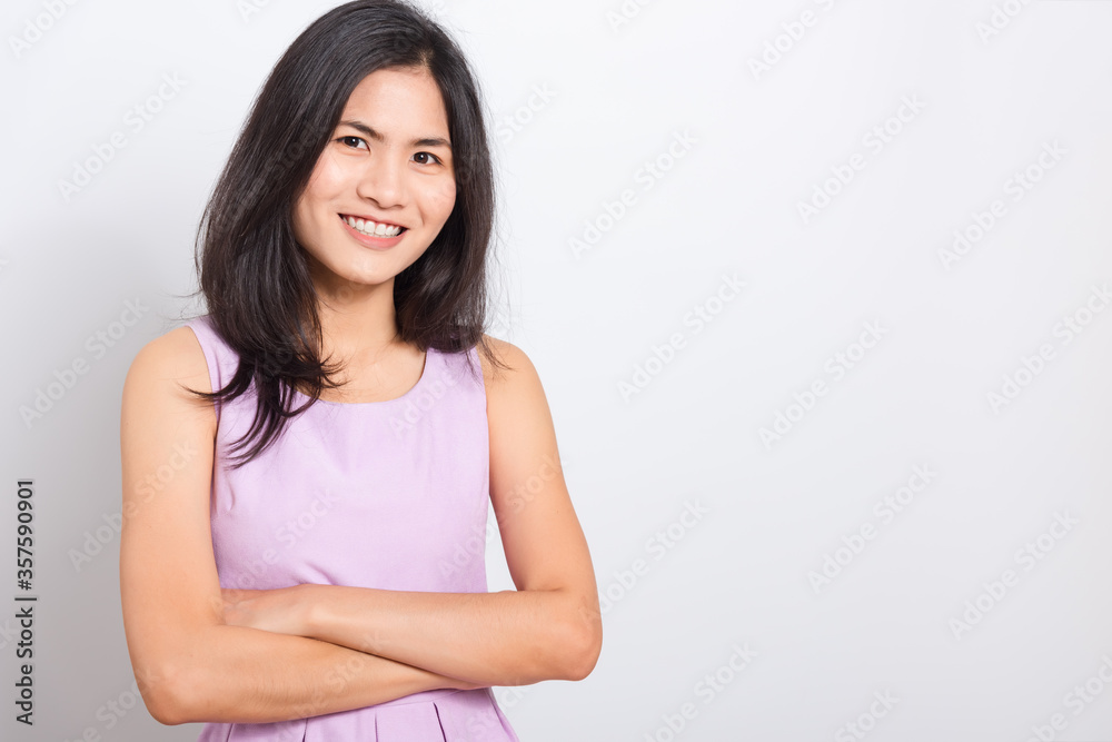 Portrait Asian beautiful young woman standing smile seeing white teeth, She crossed her arms and looking at camera, shoot photo in studio on white background. copy space to put text Portrait Asian beautiful young woman standing smile seeing white teeth, She crossed her arms and looking at camera, shoot photo in studio on white background. copy space to put text