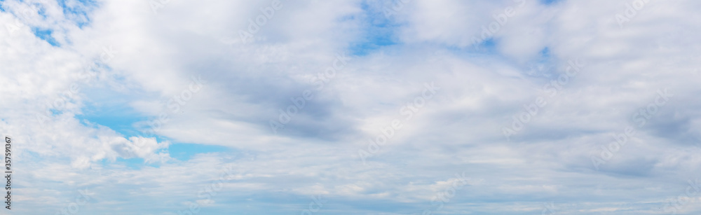 Panorama: blue sky covered with white clouds