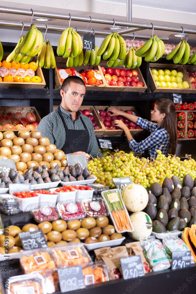  male vendor selling fresh fruits and vegetables