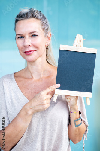 blond woman holding a chalboard photo