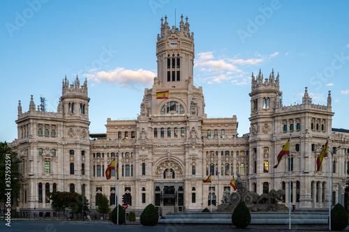 Facade of City Hall and Cibeles statue in Madrid, Spain. Spanish flag waving.