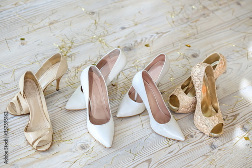 Many women's shoes stand in a row on a half-century of tinsel. Bachelorette party