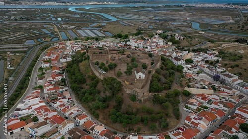 Aerial Drone View of Castro Marim Medieval Castle (Portugal), surrounded by small houses and salt pans. Guadiana River and Spain frontier in the Background