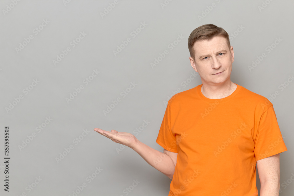 Portrait of happy man pointing with hand at empty place and smiling