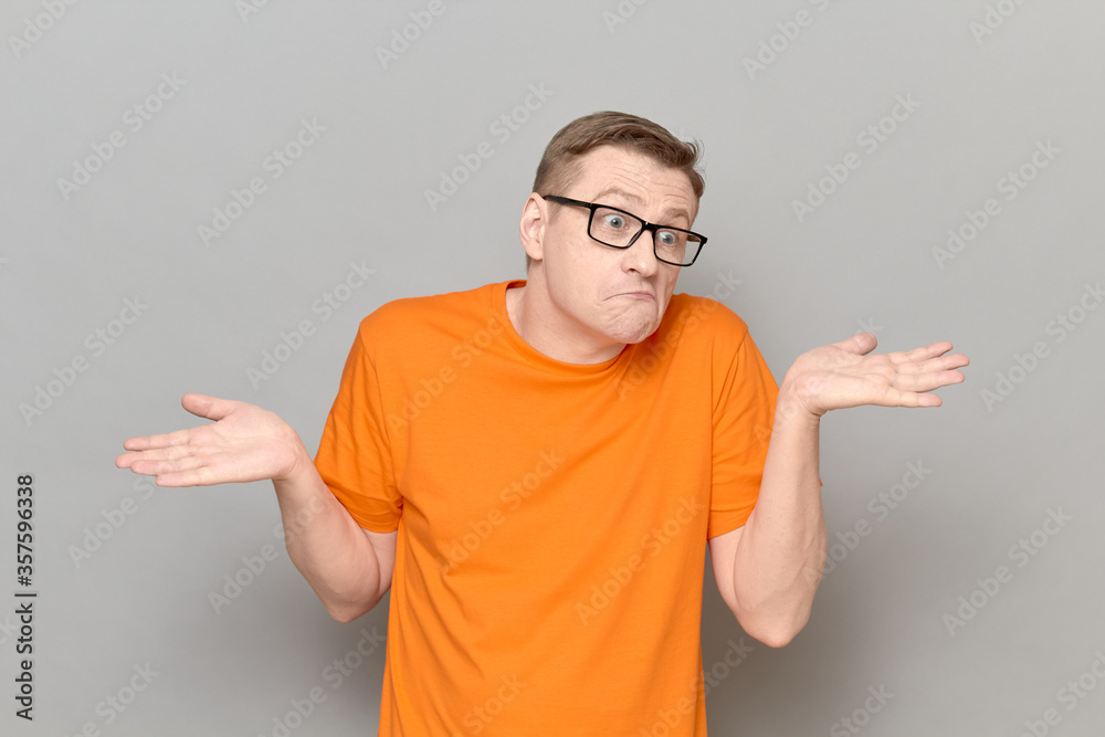 Portrait of funny confused man raising and spreading hands Portrait of funny confused man raising and spreading hands