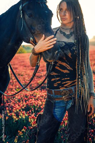 Portrait of woman and horse outdoors. Woman stroking a horse. photo