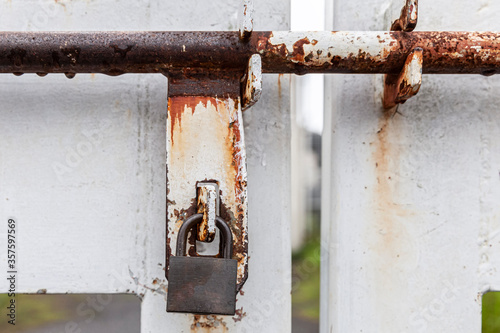door gate closed with metal chain & rusty iron lock © torsakarin