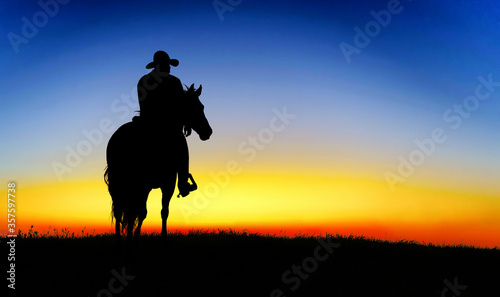Cowboy on a horse at sunset © ginettigino