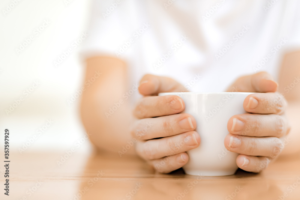 Woman hands holding white coffee cup Woman hands holding white coffee cup