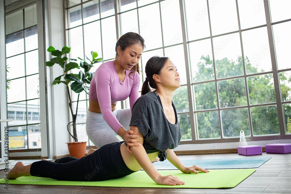 Asian woman teacher teaching yoga , Eka Pada Rajakapotasana pose ,