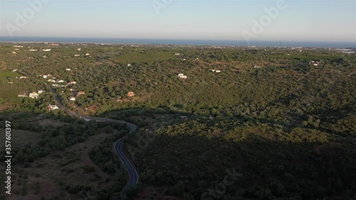 Aerial drone view over natural reservoir in Algarve, Portugal. Road and nature. Sunset landscape. Atlantic ocean in the background