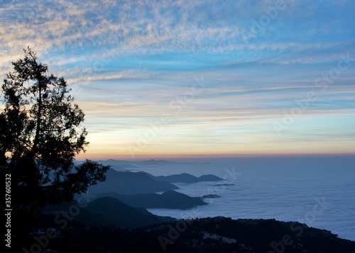  landscape view of sunrise over the mountains with fog & clouds