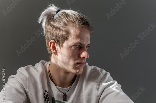 Portrait of young blond man photographed with natural light and casual clothes.