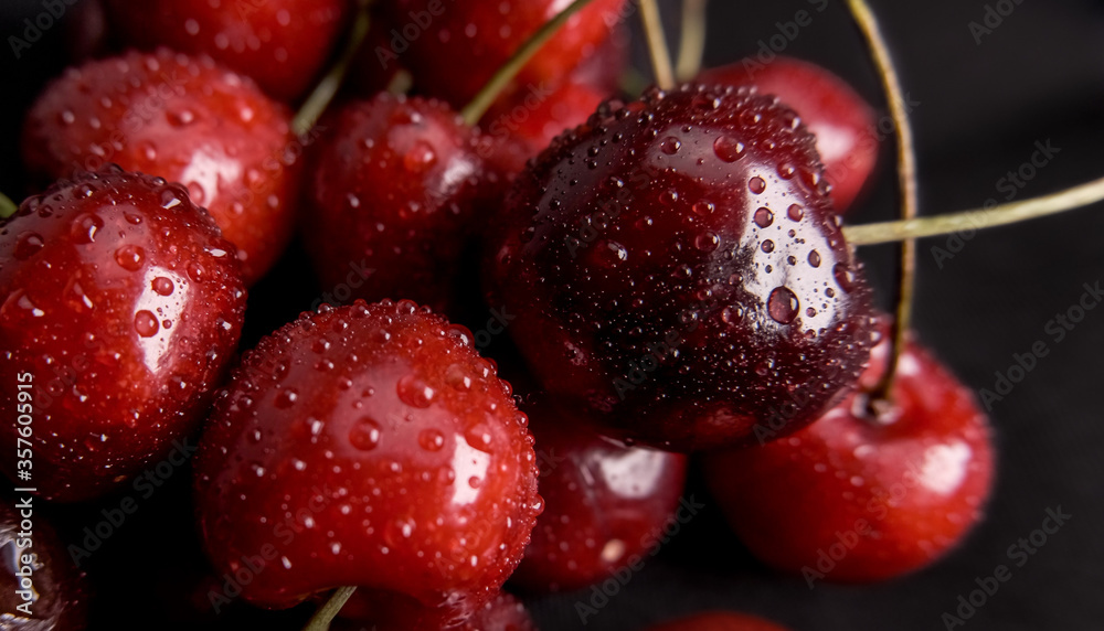 Fresh red cherries with water droplets closeup on black Fresh red cherries with water droplets closeup on black