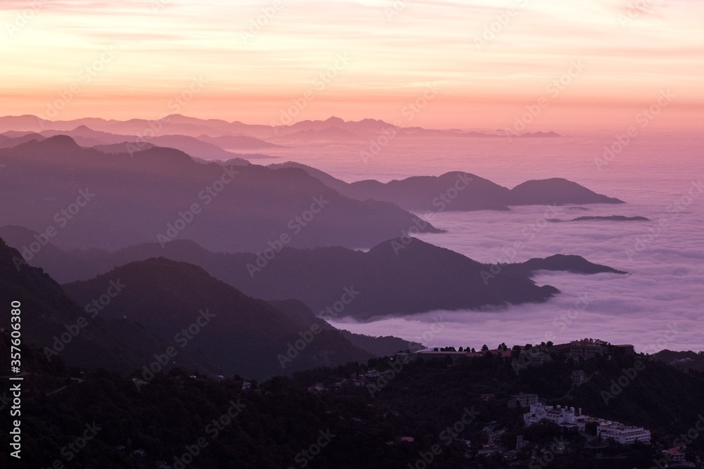 landscape view of sunrise over the mountains with fog & clouds