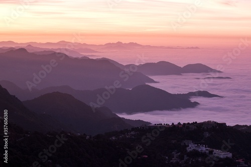 landscape view of sunrise over the mountains with fog & clouds