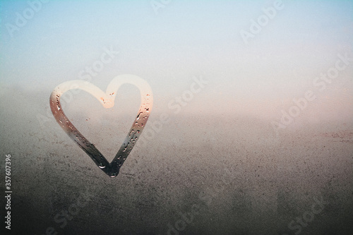 Draw a heart on the mirror with water drops. The inscription on the sweaty glass - love and heart